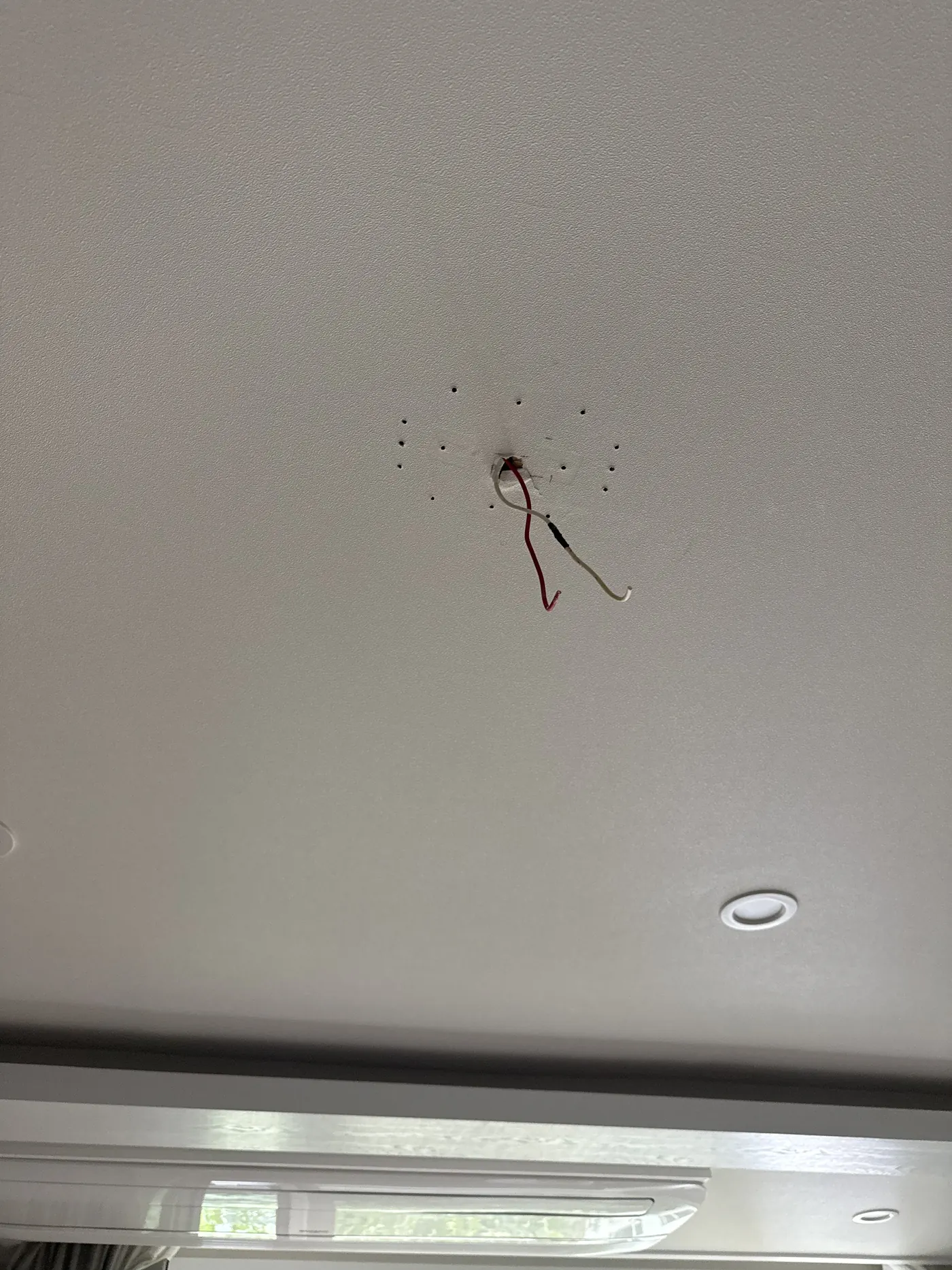 시공 전 사진 - 아파트 거실 천장 중앙에 실링팬 고정용 구멍과 나사 자국, 빨간선과 흰선 전선이 늘어진 상태